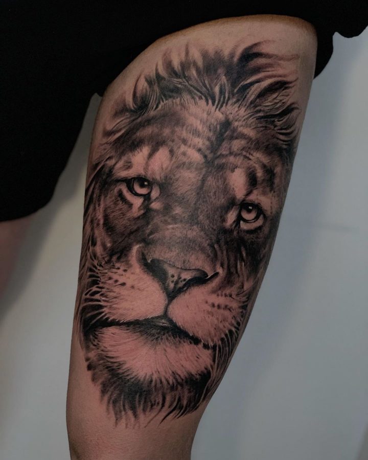 Realistische leeuwenkop in black & grey op een bovenarm
