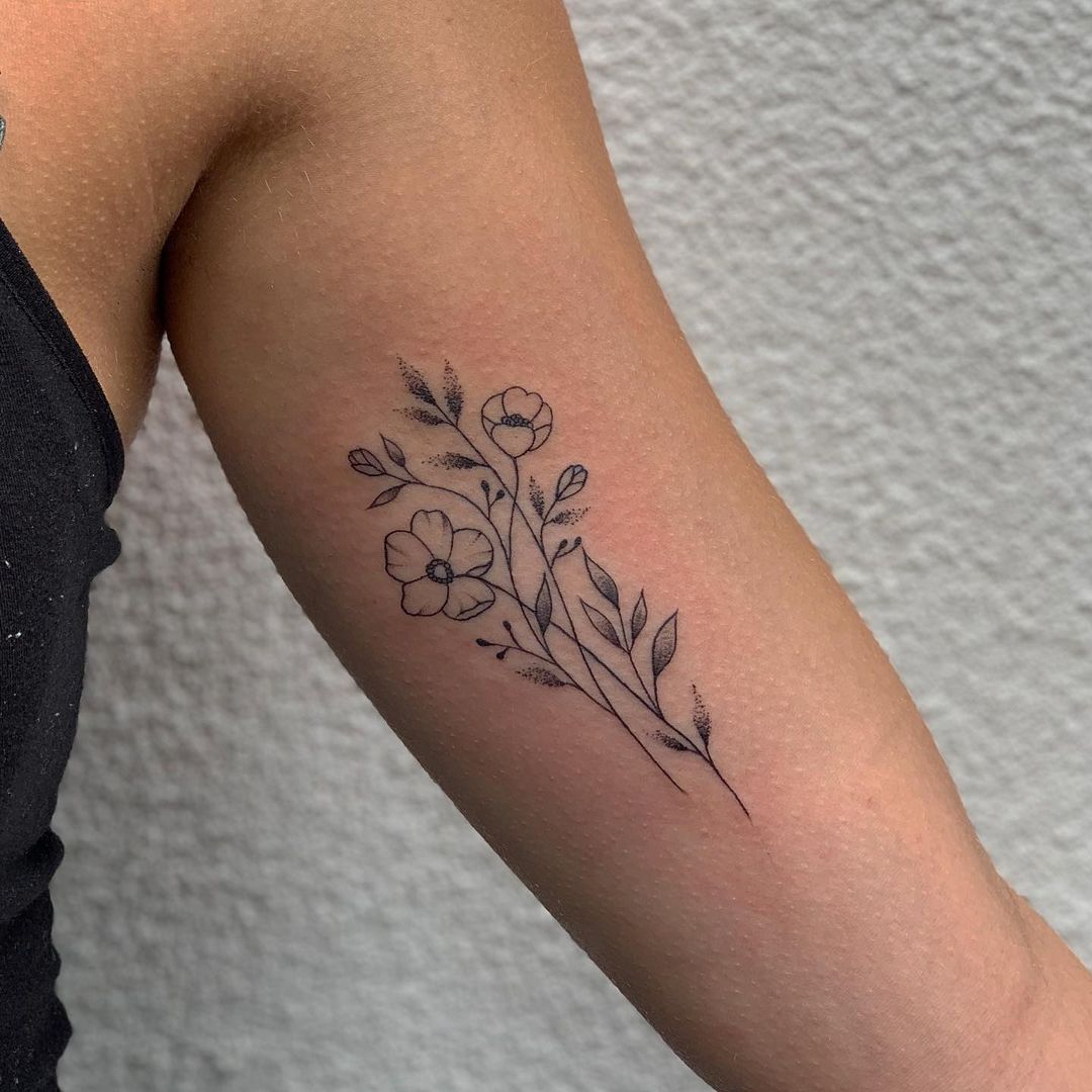 Fineline takje bloemen op de binnenkant van een bovenarm