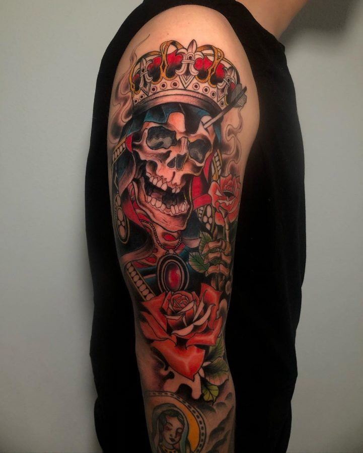 Old school schedel met kroon en rode rozen in kleur op een arm