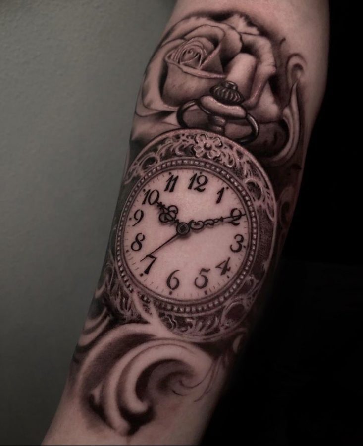 Zakhorloge met roos en sierlijke krullen op een onderarm